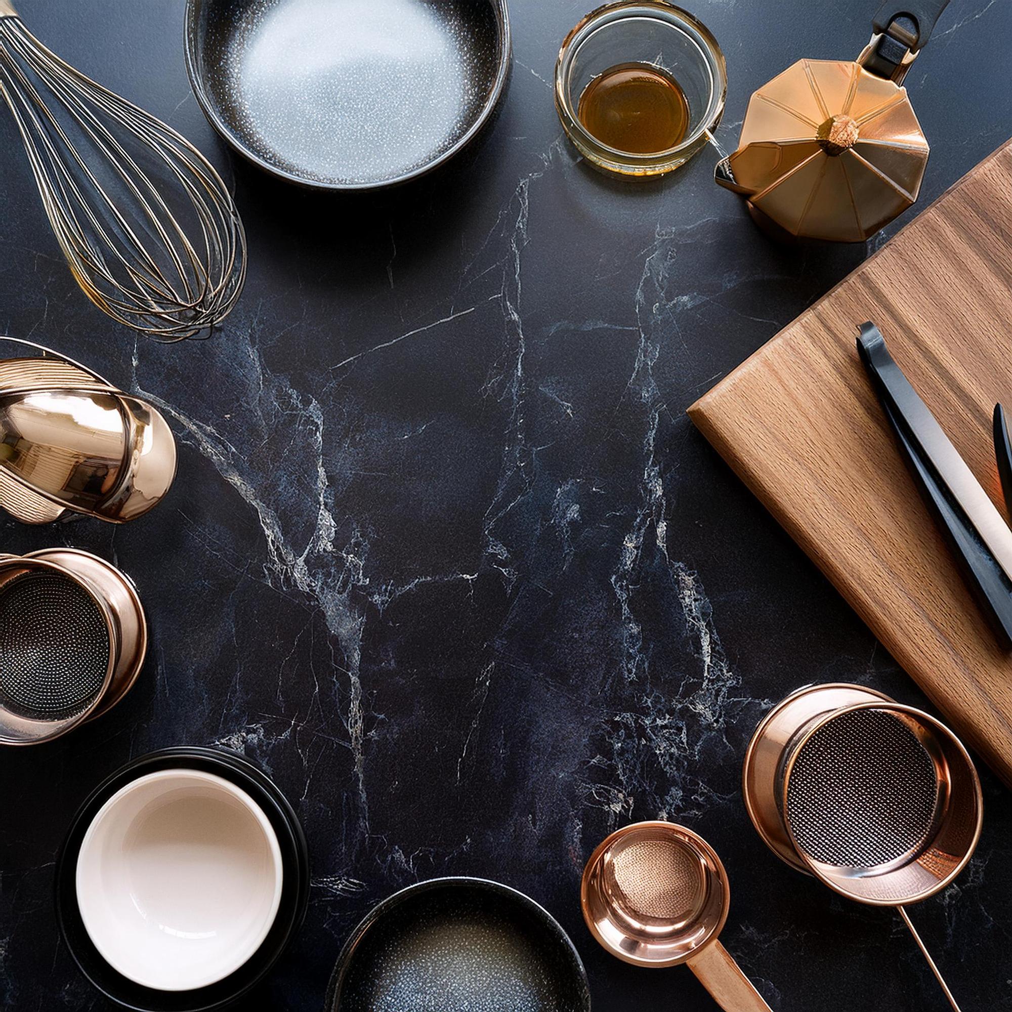 Piccola cucina di studio con superfici eleganti e utensili in vista
